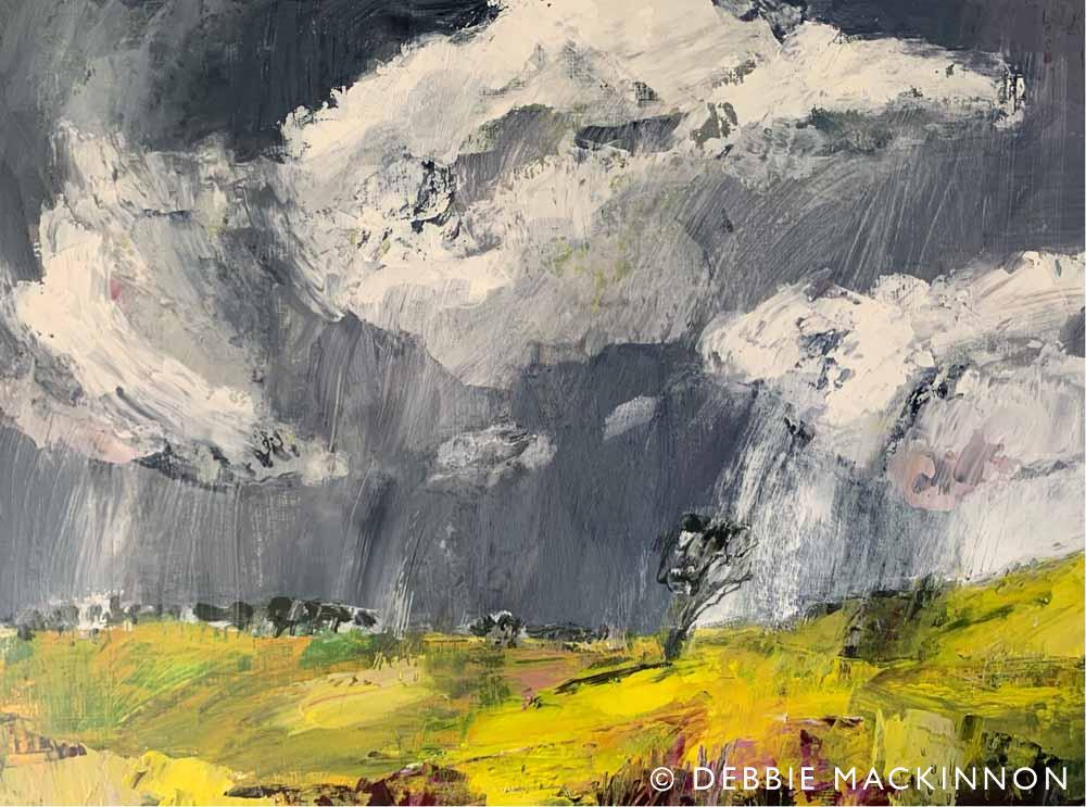 Yellow landscape with a stormy grey sky above with large white storm clouds. A single tree sits on the landscape.