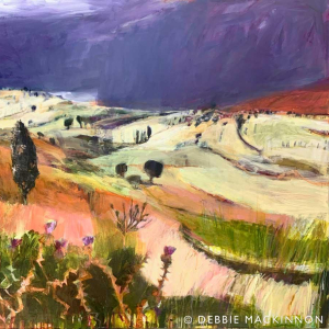 Bright yellow fields in the distance with a stormy dark purple grey sky above. Green and pink thistles in the foreground.