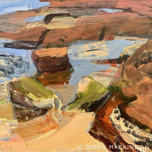 Abstract orange, pink and grey white rocks with a blue ocean
