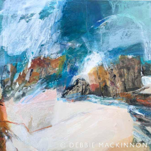 Blue sea and white sea spray next to orange and brown rocks