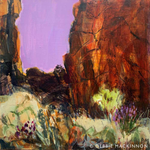 Bright orange rocks on the right and left with pink and yellow flowers and shrubs at the front and bottom and light mauve sky in between the rocks